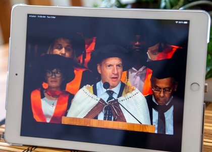 Close-up of a tablet screening graduation livestream