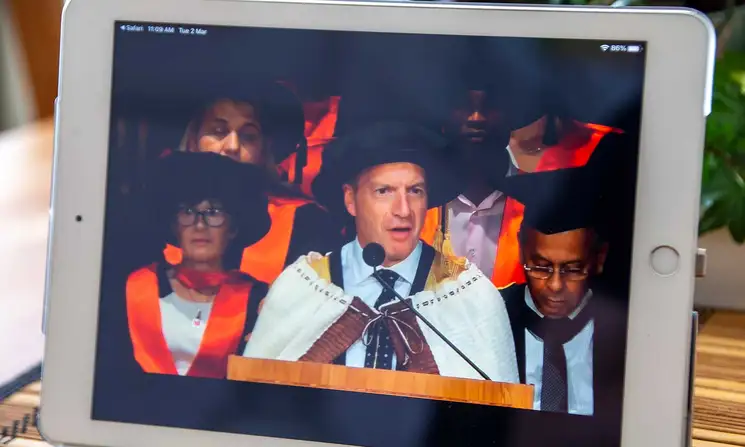 Close-up of a tablet screening graduation livestream