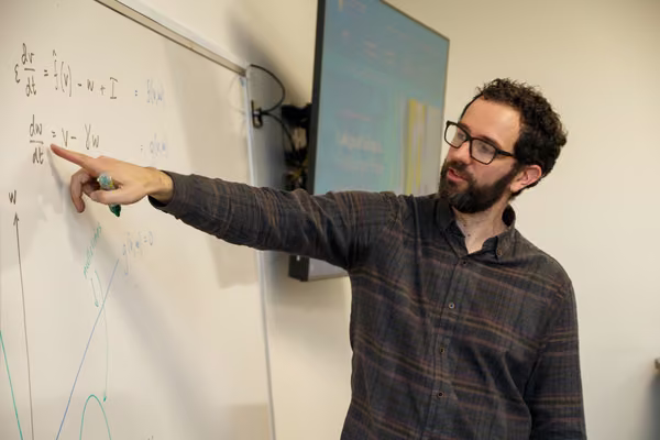 male teacher pointing at whiteboard