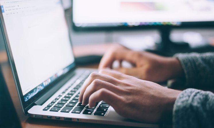 Person typing on the keyboard of a laptop computer