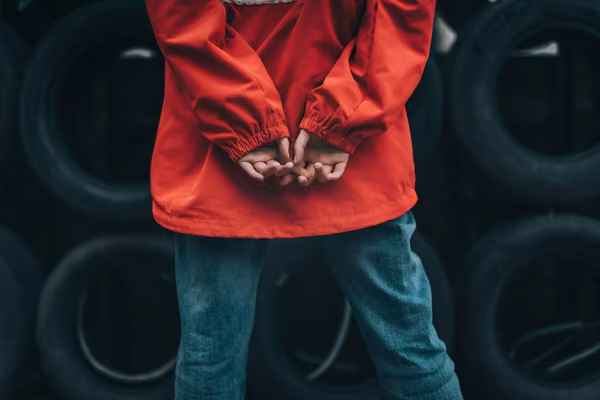child with hands behind back