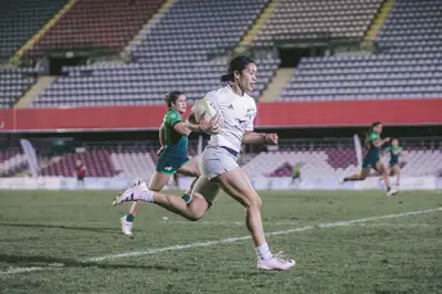 Manaia Nuku running across a field with a rugby ball under her arm