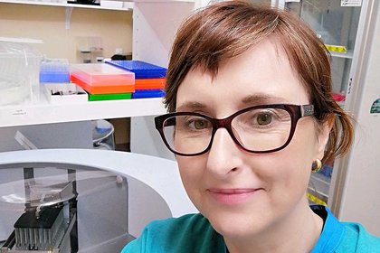 Dr Collette Bromhead working at the Gribbles Veterinary lab with testing equipment in the background.