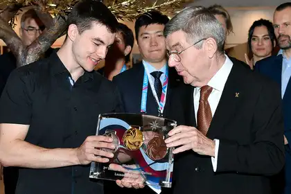Zakea Page receiving the medals he designed from the president of the International Olympic Committee, Thomas Bach.