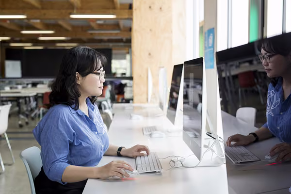 Postgraduate student working on computer in workshop