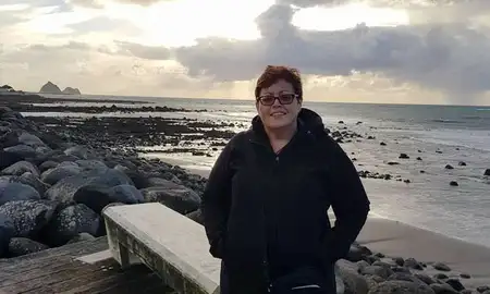 Rachelle Thurgood standing in front of a beach scene.