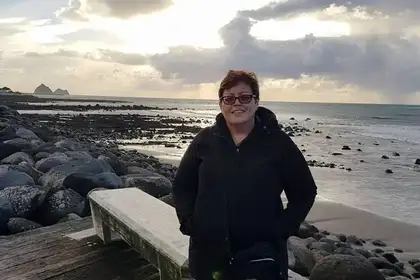 Rachelle Thurgood standing in front of a beach scene.