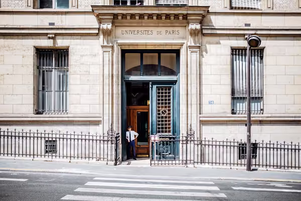 Guard standing in front of a french university building.