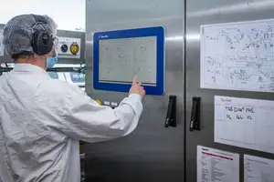 Man looking at a small whiteboard with drawings on it.