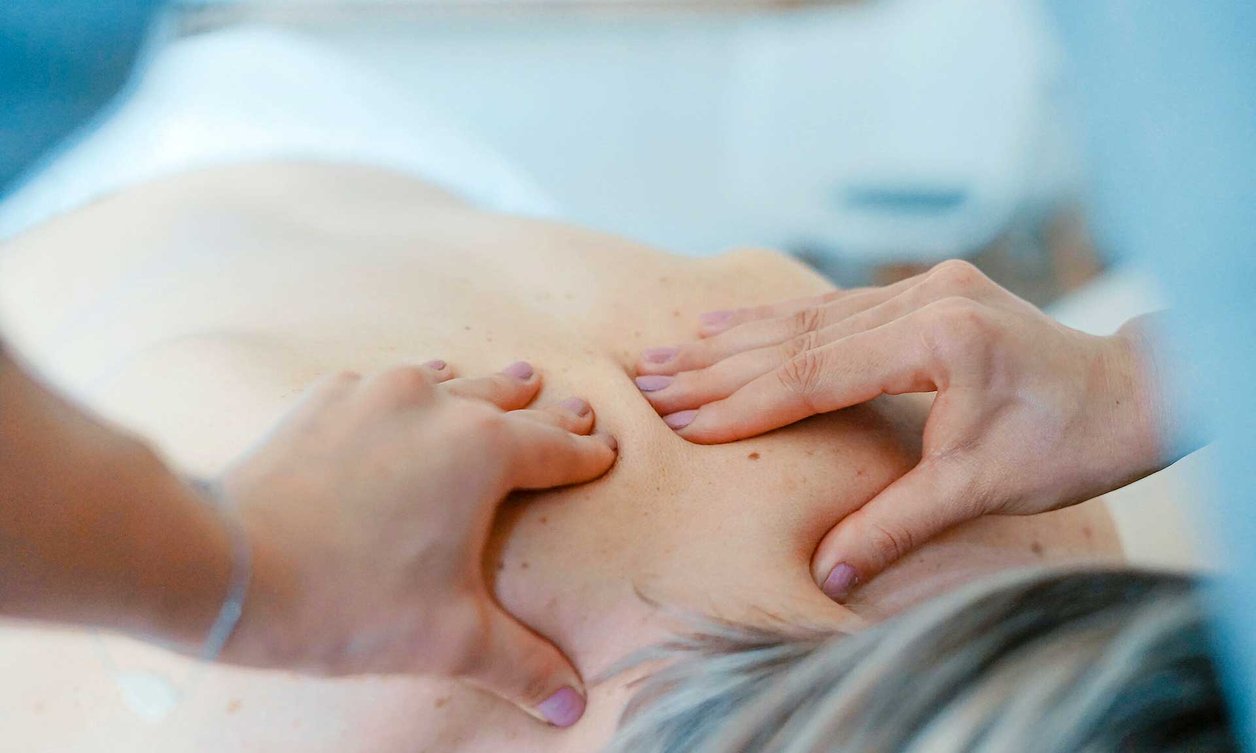 Physiotherapist performing massage on person lying down